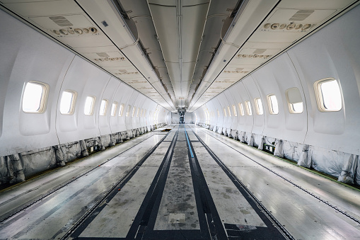 Commercial airplane under heavy maintenance. Inside of passenger cabit without seats and interior.