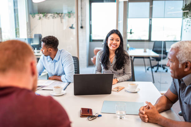 istock Coworkers in the office sitting at the table and talking 1483841815