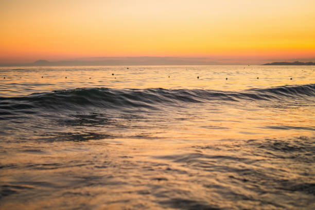 Breaking waves with sunset landscape.