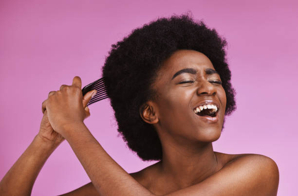 stress, hairstyle and afro brushing on beauty studio background in grooming, texture anxiety or crisis. black woman, comb and natural hair with damage, split ends or frizzy knots on isolated skincare - frizzy human hair fashion model african ethnicity imagens e fotografias de stock