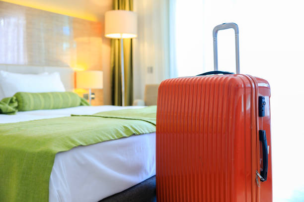 istock Orange color suitcase delivered standing in hotel room 1483845974