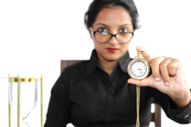 Young woman in casual wear holding antique pocket watch.