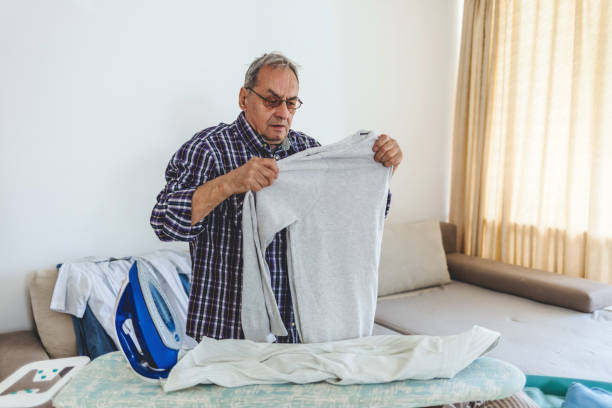 istock One man, senior man alone at his home. He is ironing his laundry. 1483851750
