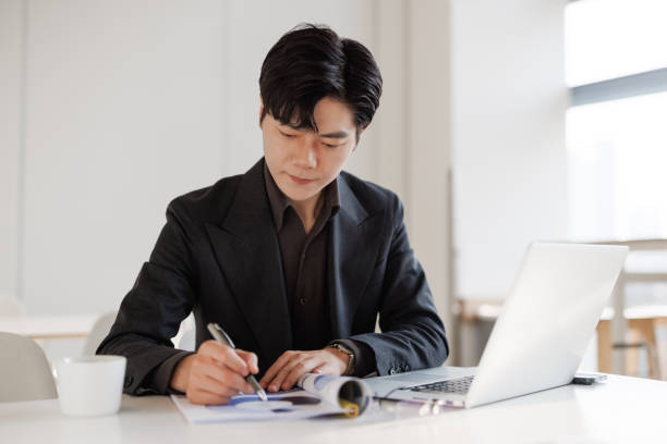 istock Young Asian businessmen make calculations on reports 1483852713