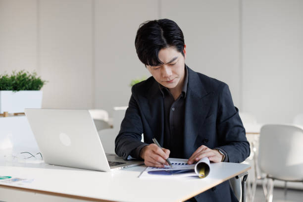 istock Young Asian businessmen calculating profits 1483852715