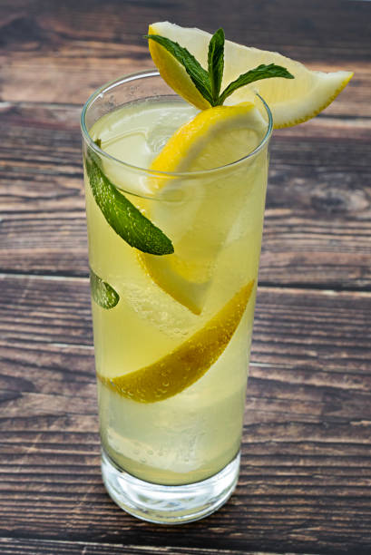 istock Cold mojitos with ice cubes, lime slices and mint leaves on wooden background. 1483853198