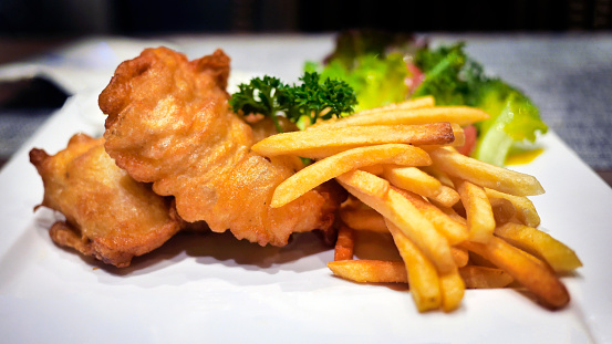 Golden color of shrimps, fish fillet and French fried, crispy deep fried, fish and chips, seafood platter s on white plate, selective focus