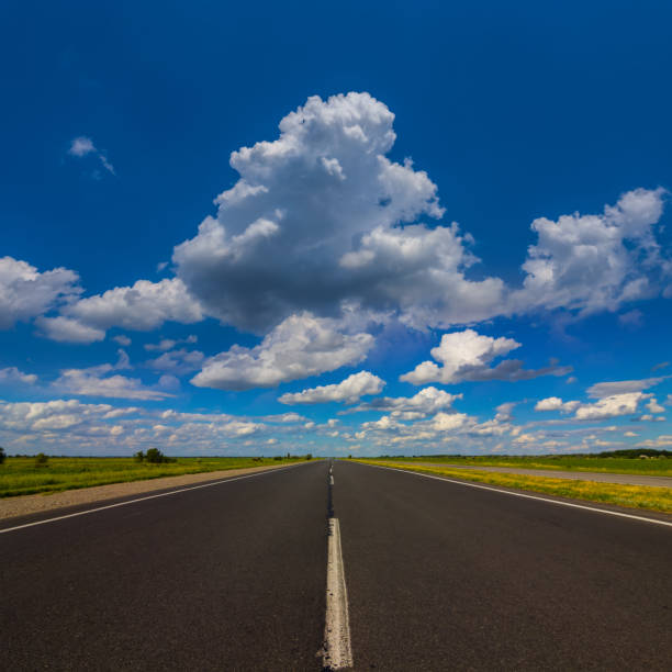 istock long asphalt road leaving far away under cloudy sky 1483854201