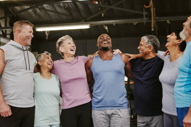 istock Senior workout group, laugh and personal trainer, smile or support for wellness goal. Elderly women, team building and happy at gym for friends, solidarity and diversity for teamwork motivation hug 1483857839