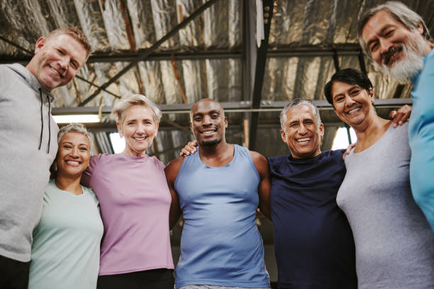 istock Senior people, fitness portrait and group support for training, workout or exercise community or gym club. Personal trainer and elderly, diversity circle in sports wellness, hug together for teamwork 1483857955