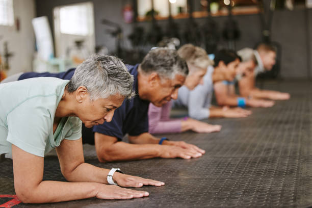 istock People, fitness and plank in class at gym for workout, core exercise or training together indoors. Diverse group or team in warm up ab muscle session for sport, health or wellness on gymnasium floor 1483859917