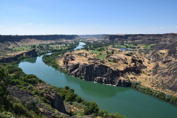 istock Snake River cutting through a rugged gorge, framed by majestic rocky cliffs and lush green grass 1483860358