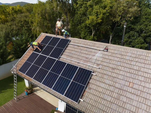 Three engineers installing solar panels on roof Engineers install solar panels on the roof of a residential house in Cape Town, South Africa. Alternative energy solutions rooftop solar stock pictures, royalty-free photos & images