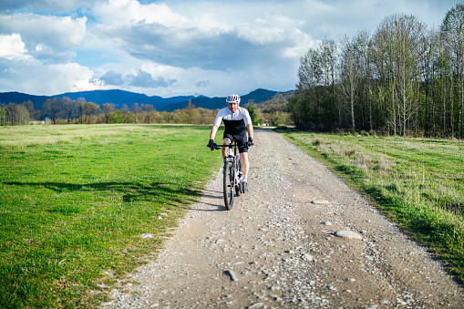 Active senior man in great athletic shape riding mountain bike.