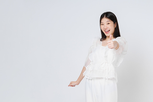 Young  woman showing thumbs up isolated on white background.