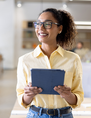 Happy African American business woman working at the office using a tablet computer and smiling