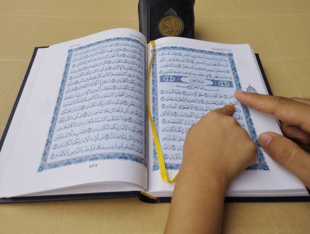istock father and son's hands reading quran 1483870324