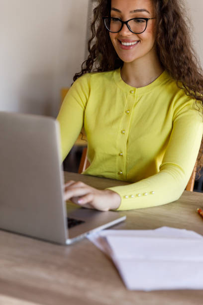 istock Smart young woman sitting at dining table, using laptop when managing home finances 1483874735