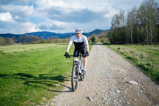 Senior man riding mountain bike in nature.