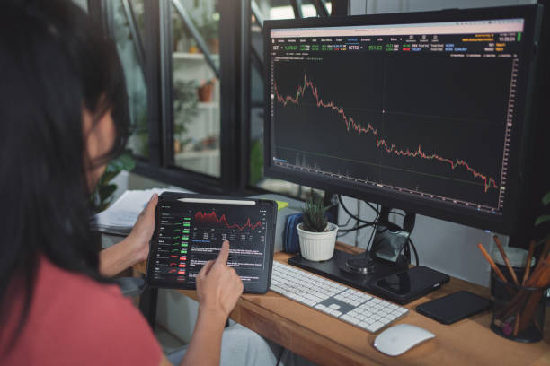 istock Asian woman trader and invester wearing casual suit using tablet and computer for analyze finance graph , investment in digital asset, working from home concept. 1483877269