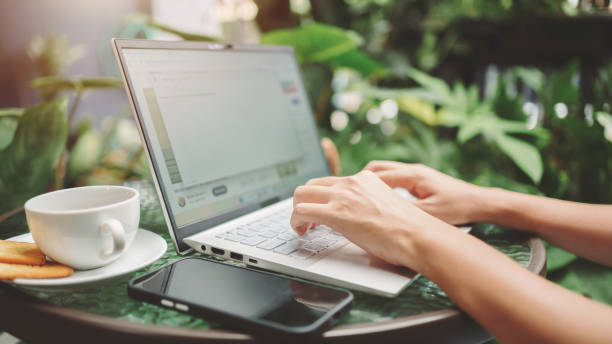 istock Close up woman using laptop for work while sitting in greenhouse, typing for a report for online work, Freelance work at home and digital nomad concept. 1483877285