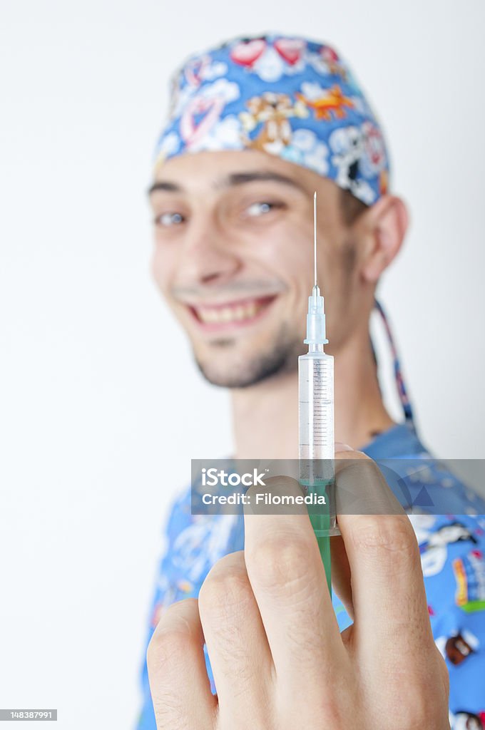 Male doctor Male doctor holding syringe and smiling Adolescence Stock Photo