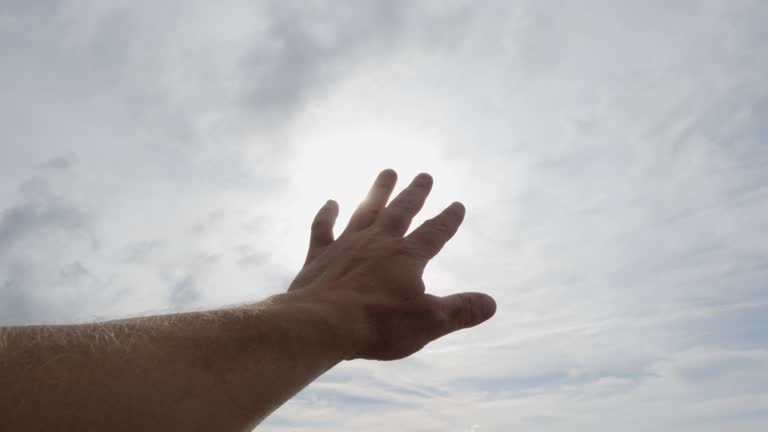 Hand reaching to the sun