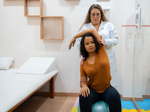 Woman exercising arm in physiotherapy clinic