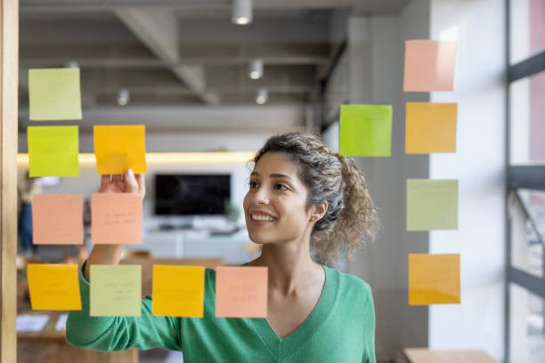 istock Entrepreneur brainstorming at the office and writing ideas on adhesive notes 1483885422
