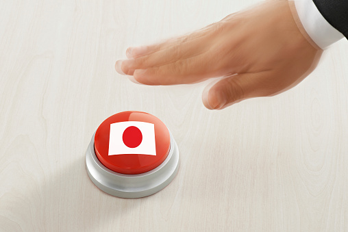 Businessman pushing a button with Japanese flag
