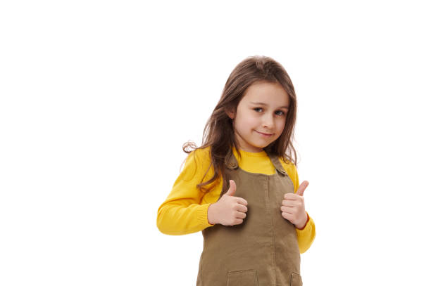 Amazed happy excited Caucasian little child girl showing thumbs up gesture, showing approval sign, excellent feedback. stock photo
