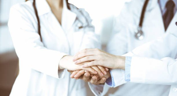istock Group of modern doctors joining hands as a circle and ready to help patients. Teamwork in medicine during Coronavirus pandemic. Covid 2019 1483892915