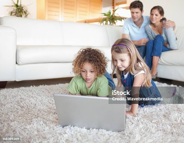 Dzieci Za Pomocą Laptopa Podczas Gdy Ich Rodzice Są Oglądać - zdjęcia stockowe i więcej obrazów 30-39 lat