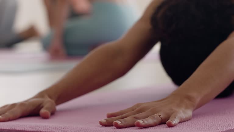 close up hands yoga woman stretching practicing childs pose on exercise mat enjoying healthy lifestyle training in wellness studio