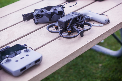 Orleans, Ontario, Canada - 09/11/2022:   DJI Avata Drone, remote controllers and virtual reality goggles headset on a picnic table.