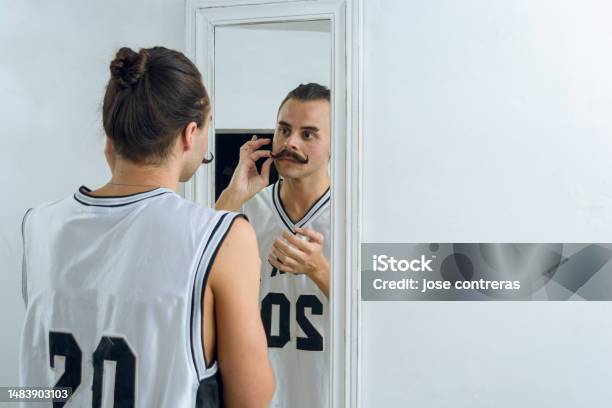 Rear View Of Gender Nonbinary Person Standing In Front Of Mirror Stock Photo - Download Image Now