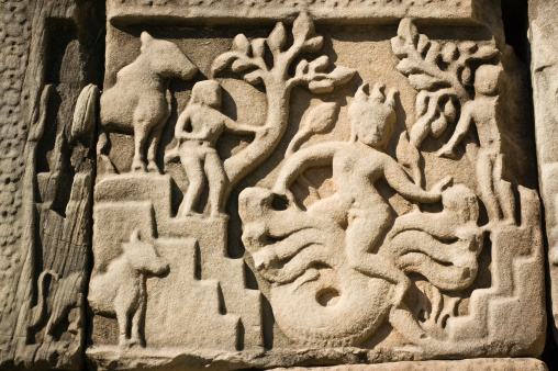 Ancient Khmer carving of the Hindu god of storms - Varuna - riding on his naga snake Makara.  Outer wall of Baphuon Temple, Angkor Thom, Cambodia.  Ancient temple, hundreds of years old.