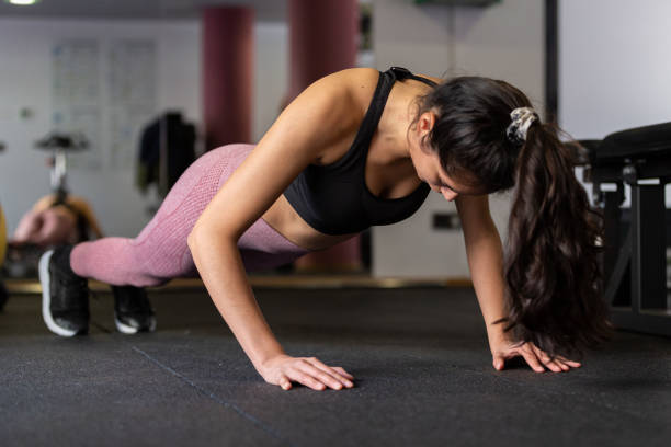istock Young woman doing pushups in the gym 1483904826