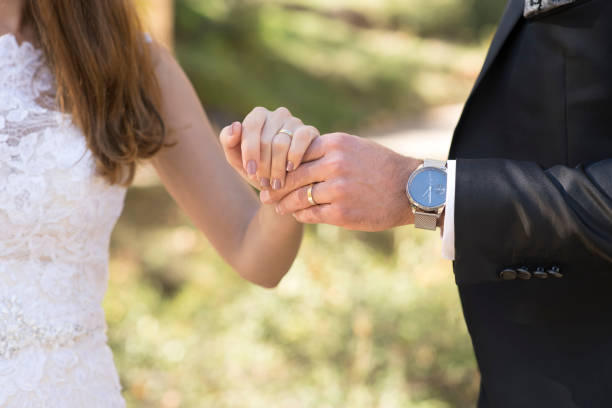 istock Hands of the bride and groom, gold ring. 1483906201