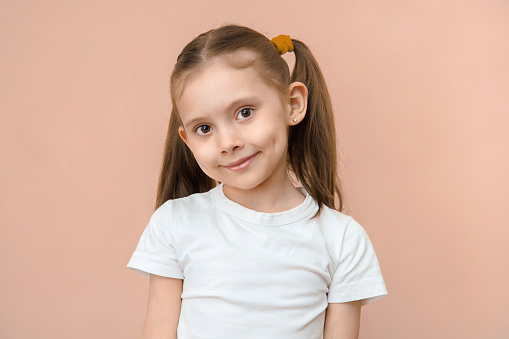 Cute caucasian preschool girl portait on a pink background.