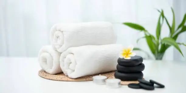 Spa accessory composition set in day spa hotel , beauty wellness center . Spa product are placed in luxury spa resort room , ready for massage therapy from professional service .