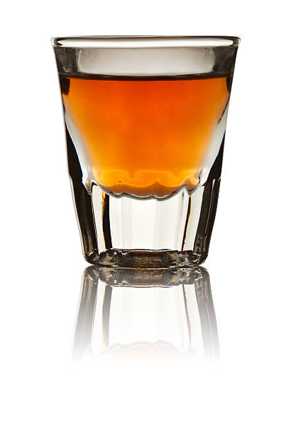 bicchierino da shot pieno di whiskey, isolato su bianco - shot glass foto e immagini stock
