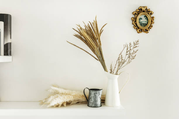 istock Jugs of various kinds and dried plants on a white wall shelf 1483923011