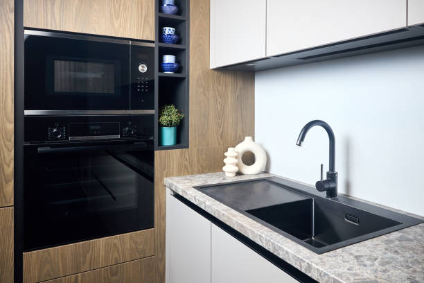 istock Urban rustic loft style kitchen interior in wooden facade and stoneware countertop tabletop with built-in appliances as sink microwave oven and oven fridge dishwasher. 1483924868
