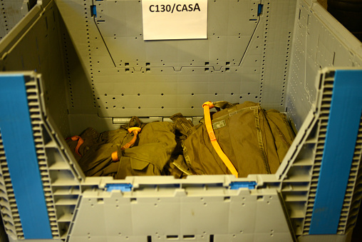 Deployed parachutes stowed in a large container to be transported to a military cargo plane