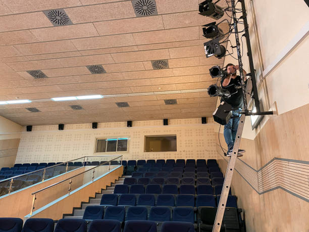 istock Sound technician on a ladder installing spotlights for a musical performance 1483930424