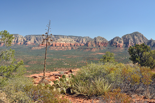 A desert town, Sedona, is surrounded by red-rock buttes, steep canyon walls and pine forest.