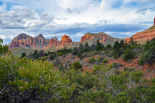 A desert town, Sedona, is surrounded by red-rock buttes, steep canyon walls and pine forest.