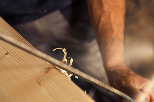 istock Chamfers and carves edges with drawknife 1483930897