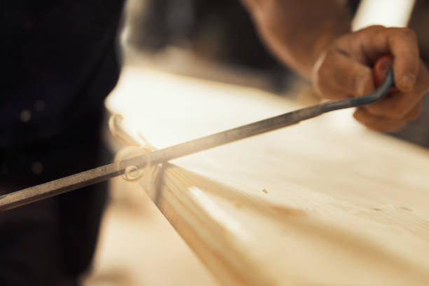 istock Chamfers and carves edges with drawknife 1483930925